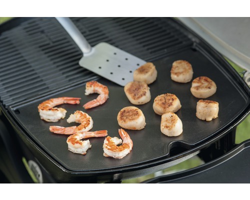 Grillade räkor och pilgrimsmusslor med grillspatel på grillplatta