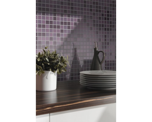 Köksscen med mosaikplattor, bänkskiva, porslin, växt och oljeflaska