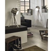 Två golvlampor i strålkastardesign med stativ i ett vardagsrum.