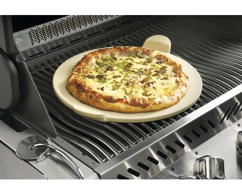 Pizza på pizzasten på en grill