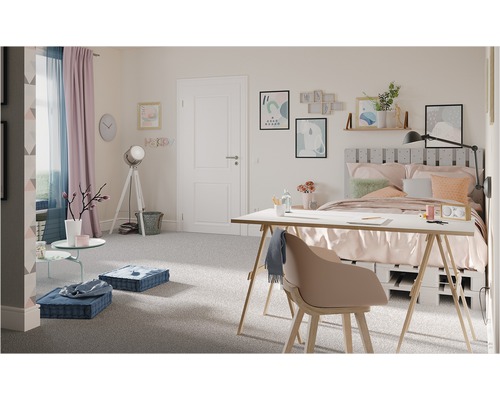 Ljust sovrum med säng, skrivbord och sittkuddar