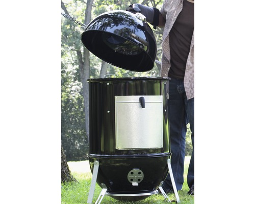 Svart kolgrill med öppet lock för utomhusbruk