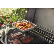 Grönsakskorg och kött på en grill