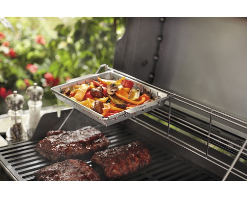 Grönsakskorg och kött på en grill