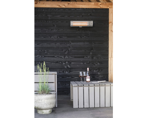 Terrass med infraröd värmare, trävägg, bord, vinflaska och glas
