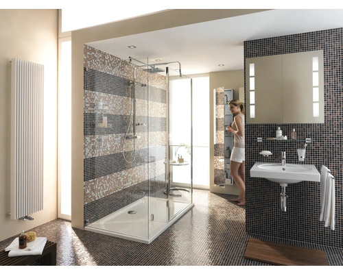 Ljust badrum med dusch, handfat och radiator framför mosaikplattor