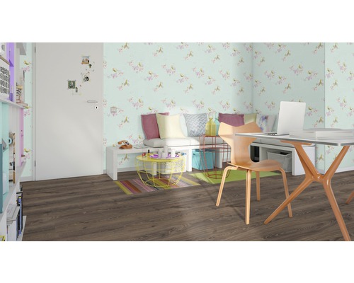 Vardagsrum med skrivbord, stol, bänk, blommig tapet och brunt laminatgolv