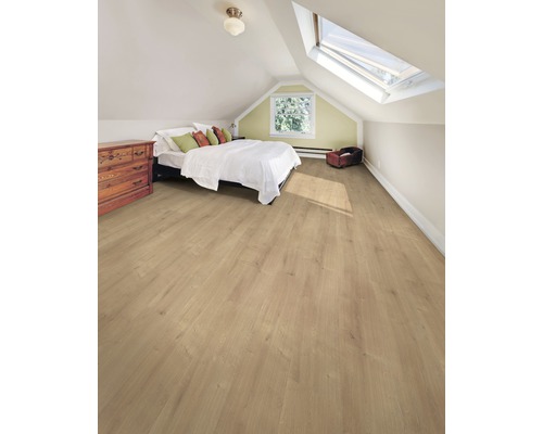 Ljust vindsrum med laminatgolv, säng, byrå och takfönster.