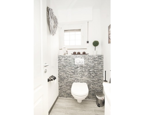 Modern gästtoalett med toalett, mosaikvägg och dekoration