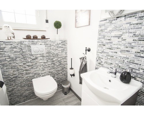 Ljust badrum med toalett, handfat och mosaikplattor