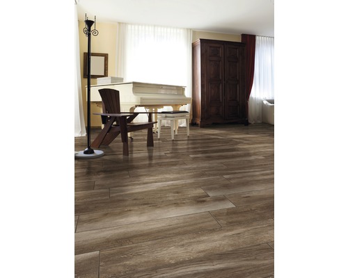 Ljust rum med trägolv, piano, stol, skåp och golvlampa