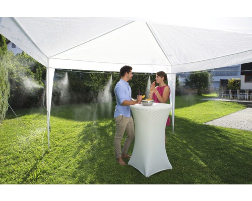 Scen med ett partytält med dimsystem och två personer i trädgården