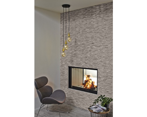 Vardagsrum med öppen spis, fåtölj och hänglampa