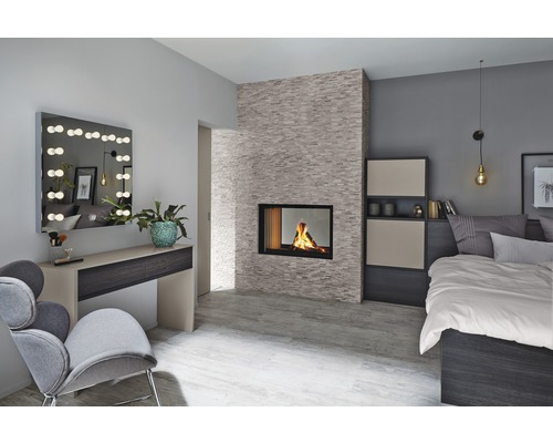 Ljust sovrum med öppen spis, säng och sminkbord med spegel