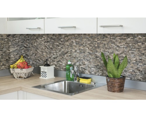 Köksscen med diskho, kran, mosaikplattor och dekorationer på en arbetsbänk