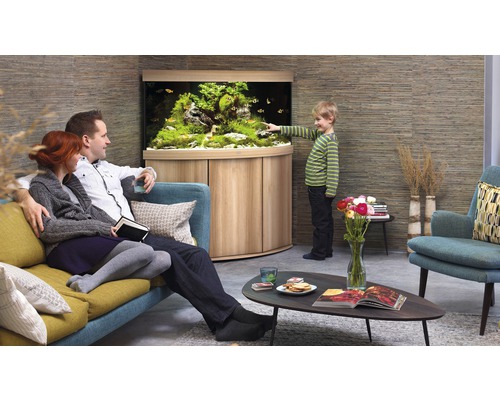 Familj tittar på akvarium i vardagsrummet med träskåp