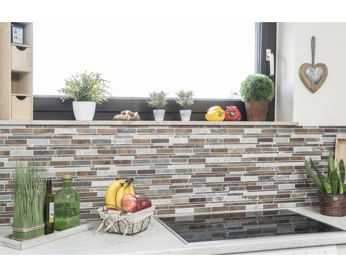 Köksscen med mosaikvägg, örter, fruktskål och spishäll