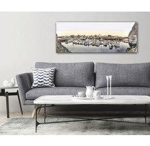 Dekorativ väggbild med hamnmotiv ovanför en soffa