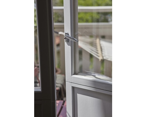 Öppen dörr med metallhandtag och utsikt över ett uterum med hängmatta