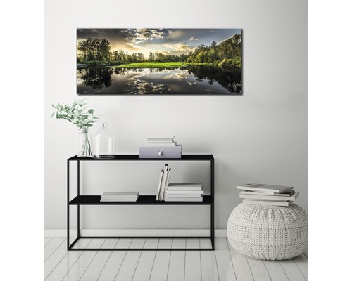 Väggbild med landskapsmotiv över svart hylla