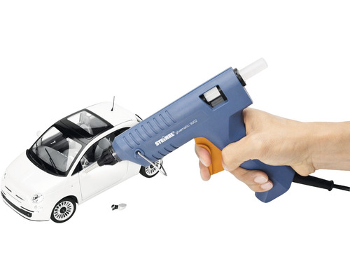 Häftpistol i handen framför en leksaksbil