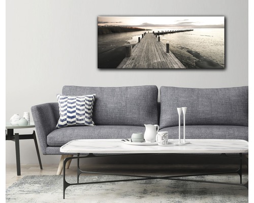 Vardagsrum med soffa och en väggmålning med en brygga som leder till vattnet