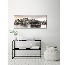 Dekorativ canvas med stadsbild ovanför en svart konsol