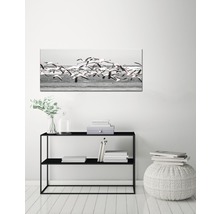 Dekorativ väggbild med en bild av flamingor över havet, hängd ovanför en minimalistisk hylla.