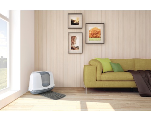 Vardagsrum med kattlåda, soffa och väggdekoration