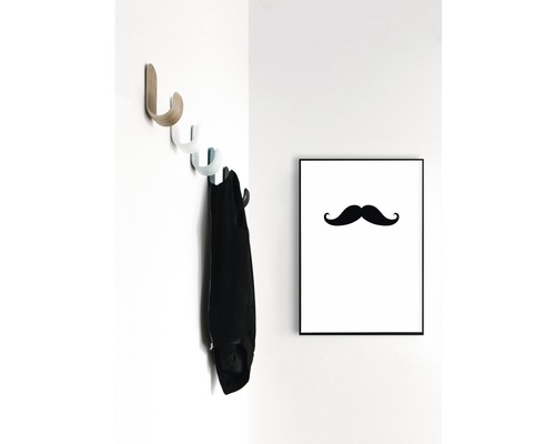 Vägghylla med jacka och inramad mustaschbild på väggen