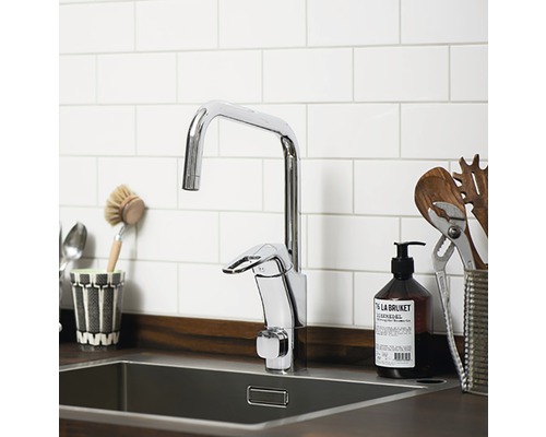 Diskho med blank armatur framför vit tegelvägg