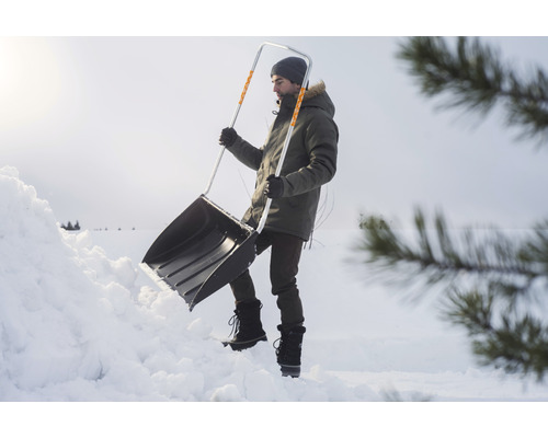 Man skottar snö med en snöskyffel