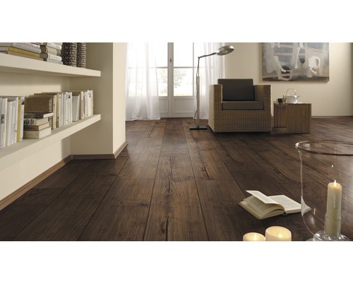 Vardagsrum med laminatgolv i träutseende, hyllor, fåtölj och dekoration