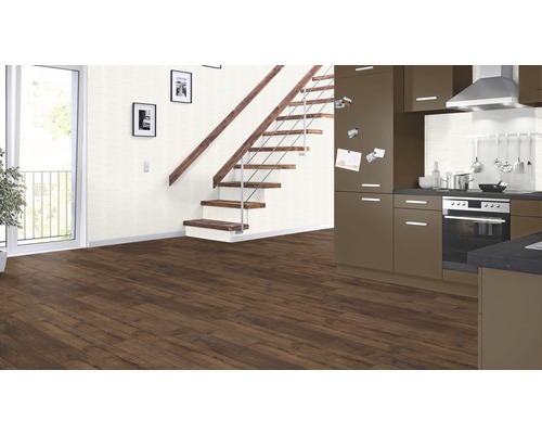 Interiör med brunt laminatgolv, trappa, kök och balkongdörr.