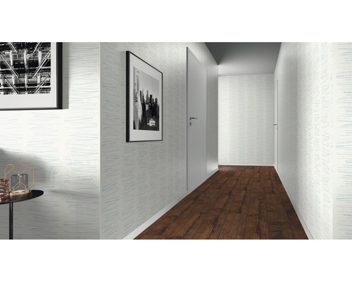 Hall med mönstrad tapet, tavlor och trägolv