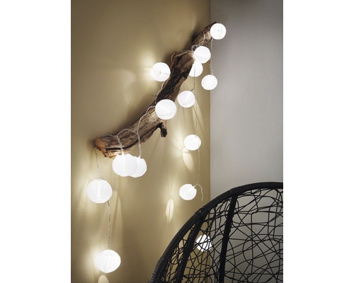 Dekorativ ljusslinga med sfäriska lampor fästa på en gren
