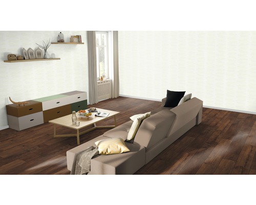 Vardagsrum med soffa, bord, byrå och vägghyllor i ett ljust rum.