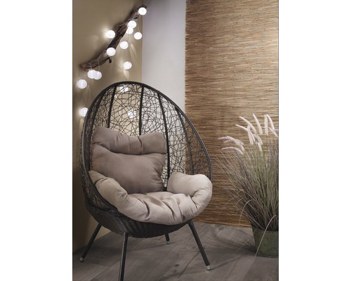 Scen med en svart hängande stol med kuddar och dekorationer