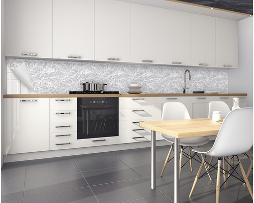 Modernt kök med vita köksskåp, matbord och väggpaneler med bladmönster