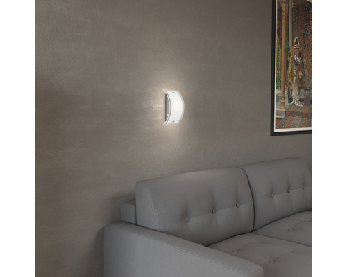 Vägglampa av glas och metall i ett vardagsrum