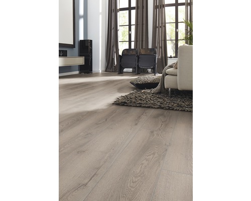 Ljust vardagsrum med laminatgolv i träoptik, fåtöljer, matta och gardiner