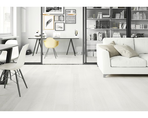 Ljust rum med trägolv, skrivbord och soffa