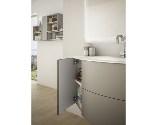 Badrum med tvättställsskåp, öppet skåp och upplyst spegel