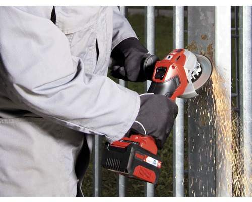 En person slipar ett metallgaller med en sladdlös vinkelslip och gnistor flyger.