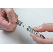 En LED-list hålls av två händer.