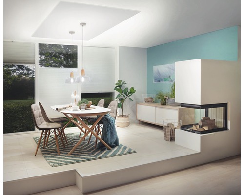 Ljust vardagsrum med matbord, stolar, öppen spis och byrå för en mysig atmosfär