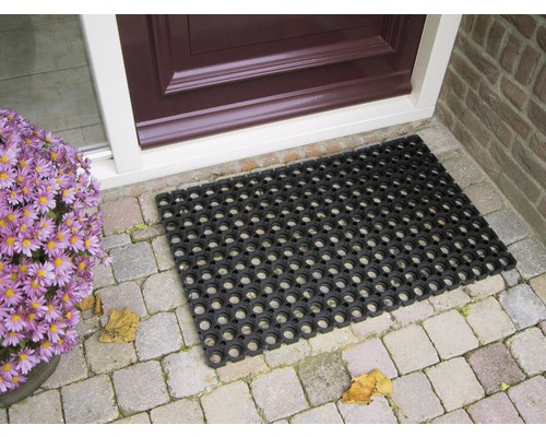 Svart gummimatta framför en ytterdörr