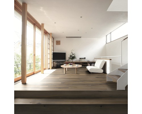 Ljust vardagsrum med trägolv, trappa och fönster