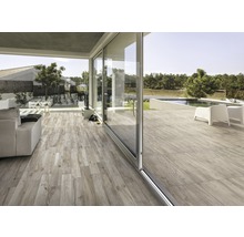 Ljust vardagsrum med träimitation och skjutdörrar till trädgården med pool