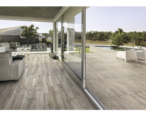 Ljust vardagsrum med träimitation och skjutdörrar till trädgården med pool